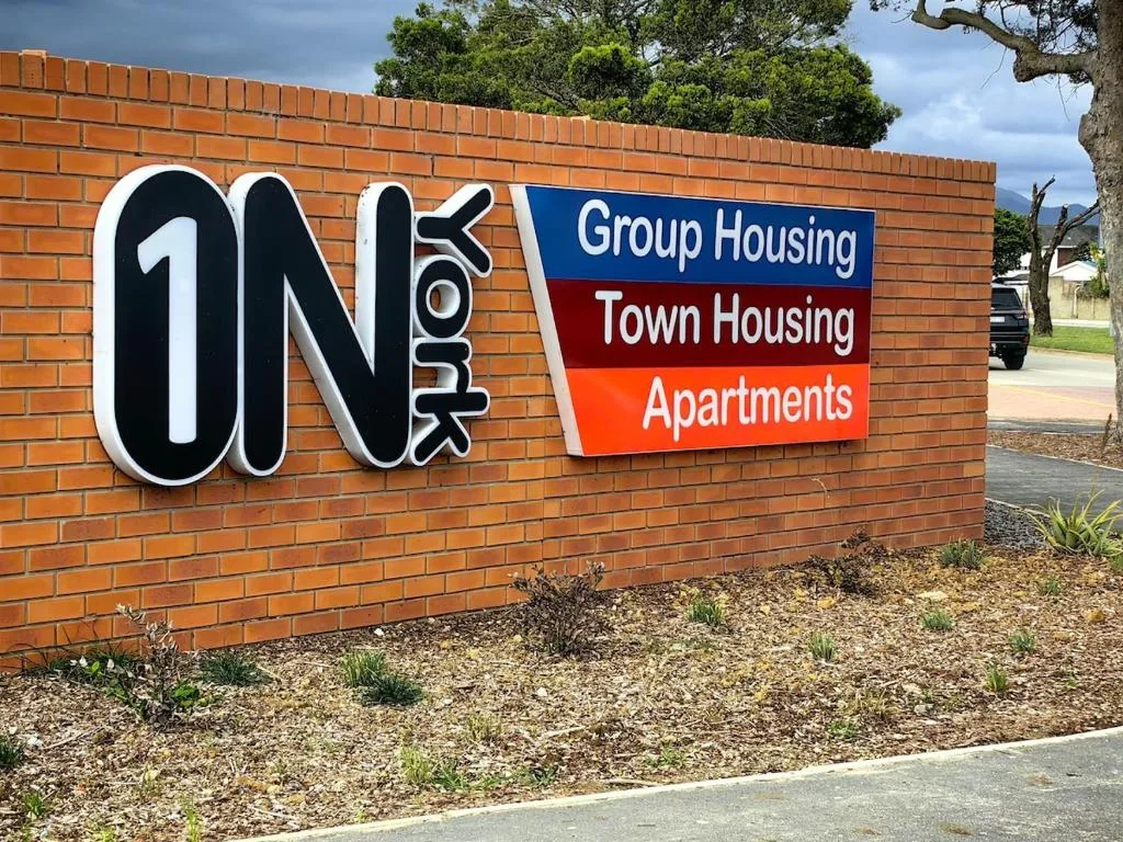 Brick building sign for One York Group Housing and Town Housing Apartments