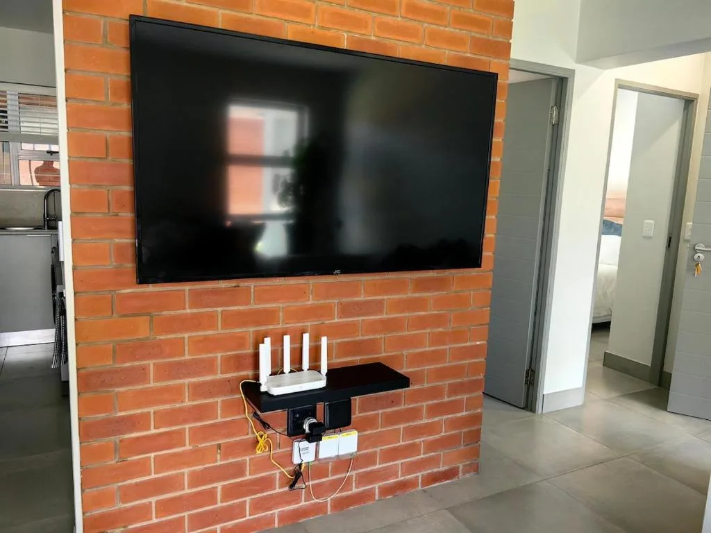Modern lounge with flat-screen TV mounted on red brick fireplace
