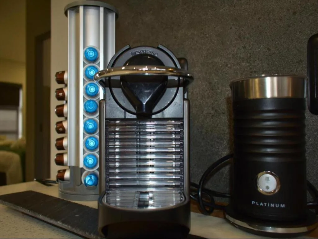 Nespresso machine with milk frother and capsule storage on kitchen counter