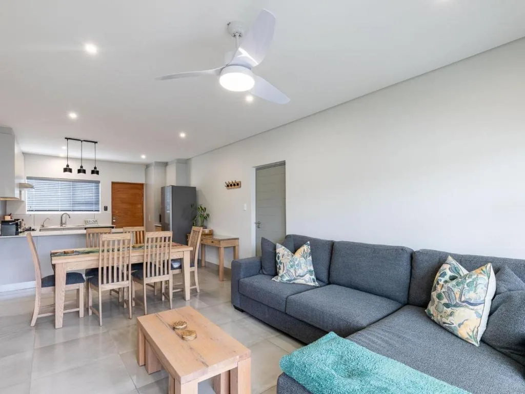 Modern open-plan lounge with gray sofa and wooden coffee table