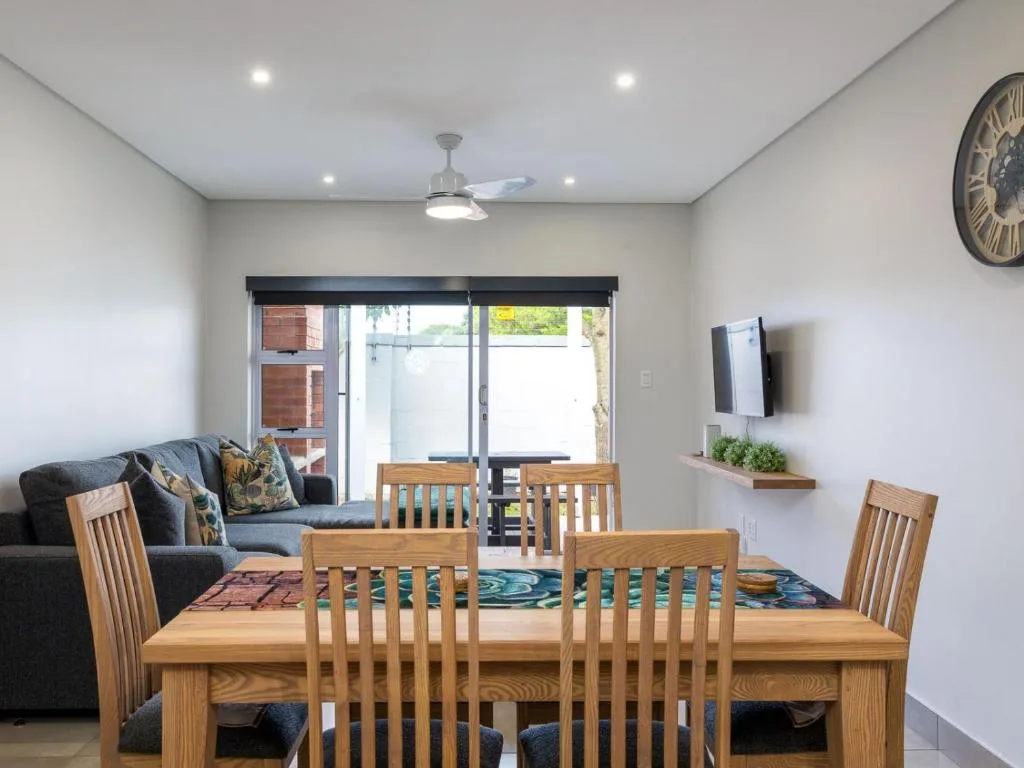 Open-plan living area with dining table, sofa, and glass sliding doors