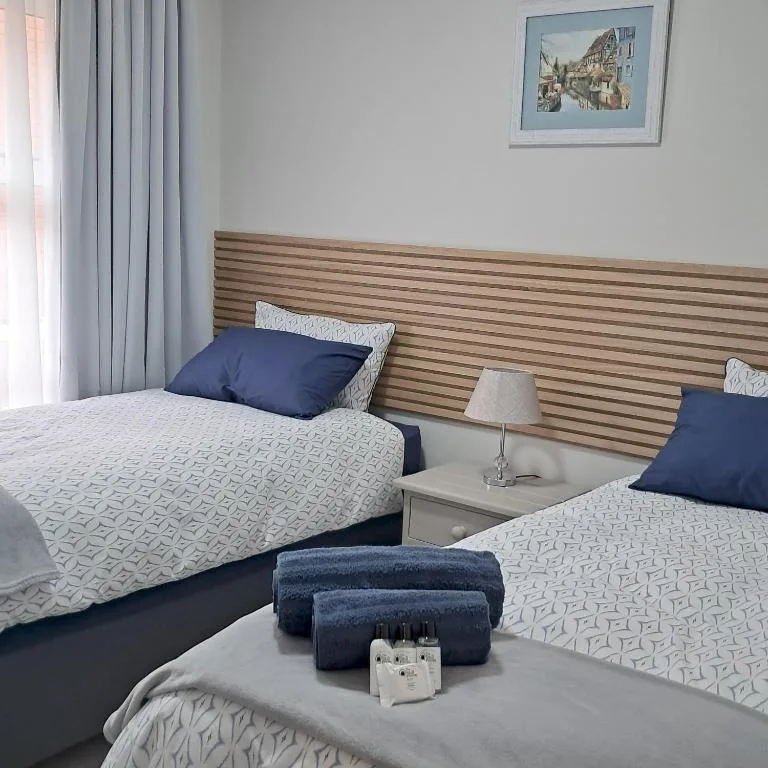 Twin bedroom with striped wooden headboard and navy accents