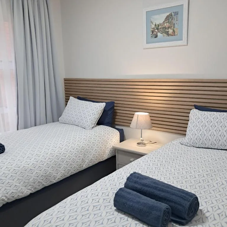 Twin bedroom with striped wooden headboard and patterned bedding