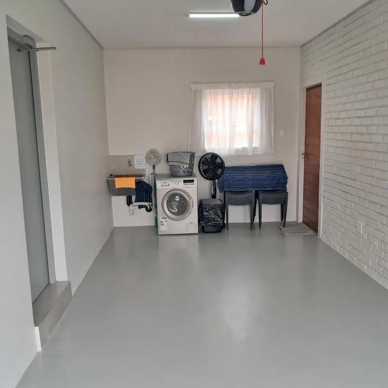 Laundry room with washing machine, drying rack, and storage shelves