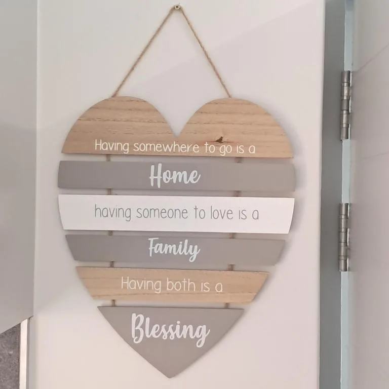 Wooden heart-shaped wall sign with inspirational home and family quote