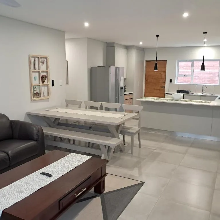 Modern open-plan dining area with light wood table and bench seating