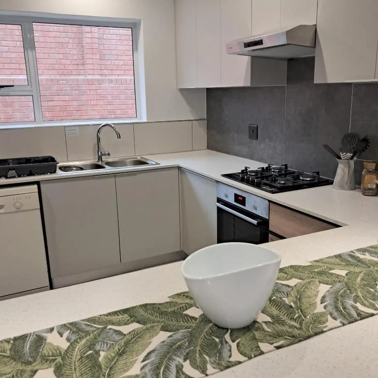 Modern kitchen with white cabinetry, gas cooktop, and stainless steel appliances
