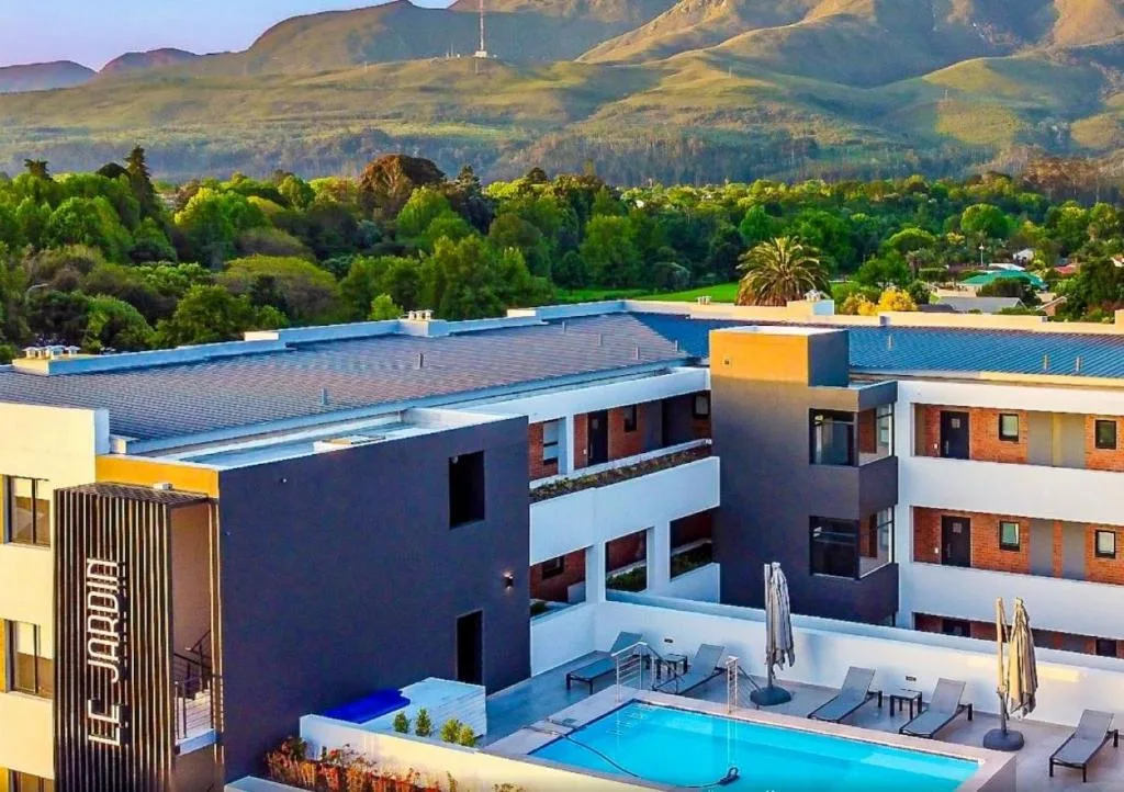 Bright blue swimming pool with loungers and mountains backdrop