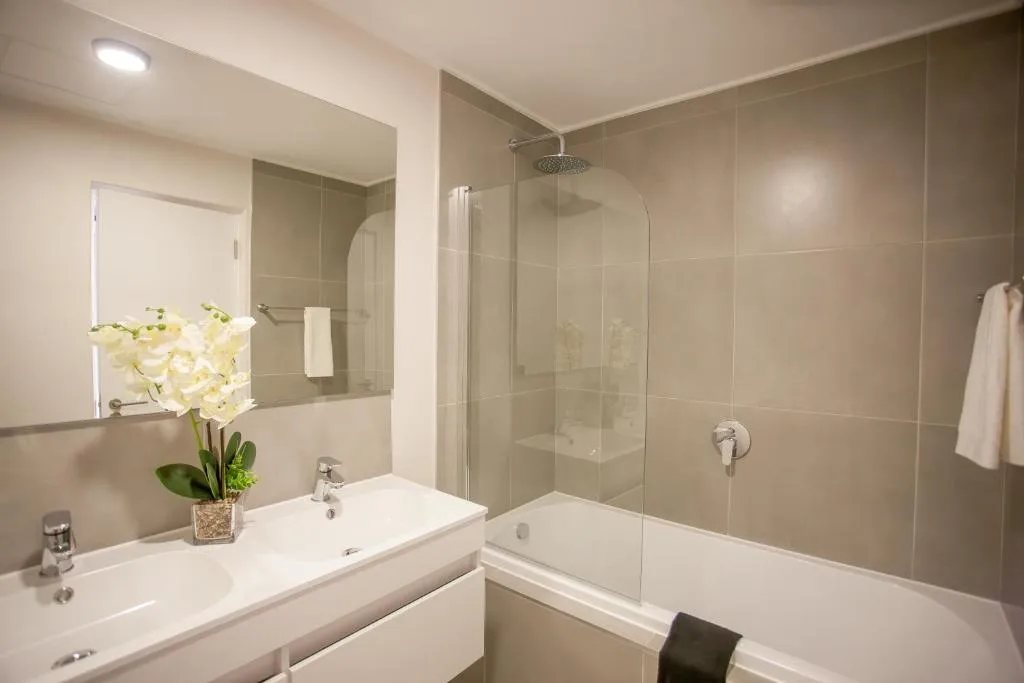 Modern bathroom with vanity, mirror, bathtub and glass shower enclosure
