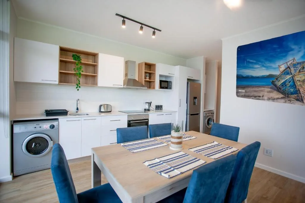 Dining table with blue chairs in open-plan kitchen and dining area