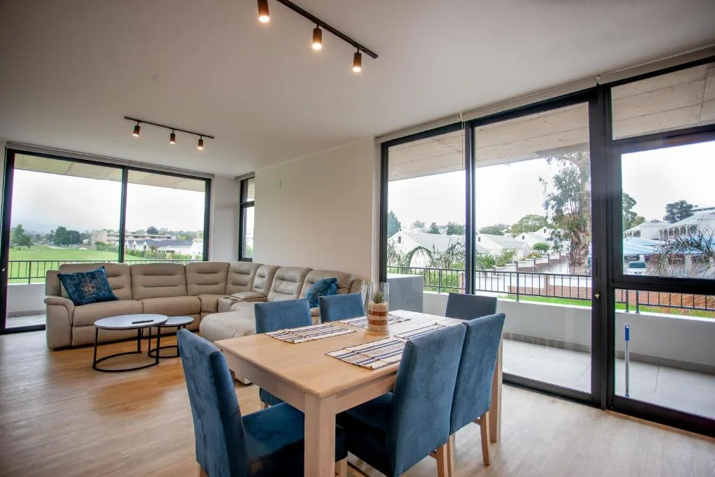 Open-plan lounge and dining area with modern furnishings and garden views