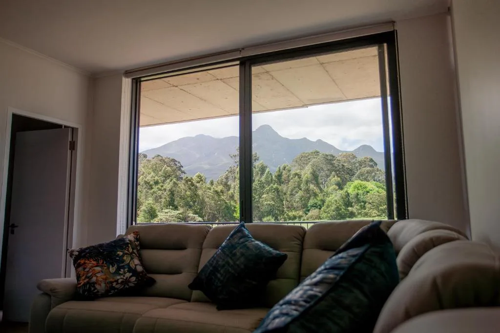 Comfortable gray sofa with mountain view through large windows