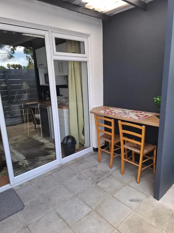 Outdoor patio area with wooden bar seating and sliding glass doors