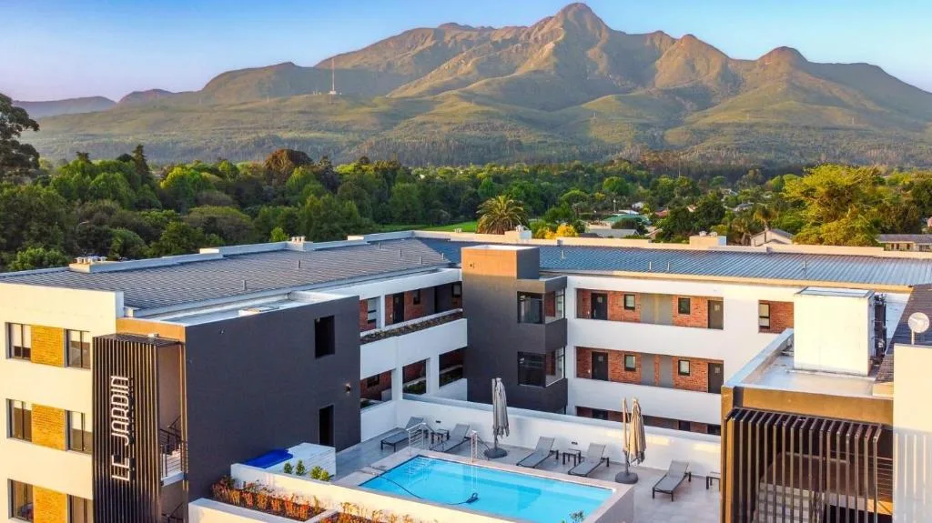 Swimming pool with mountain backdrop and modern apartment buildings