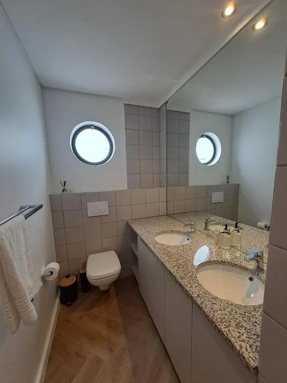 Modern bathroom with dual vanity sinks and porthole windows