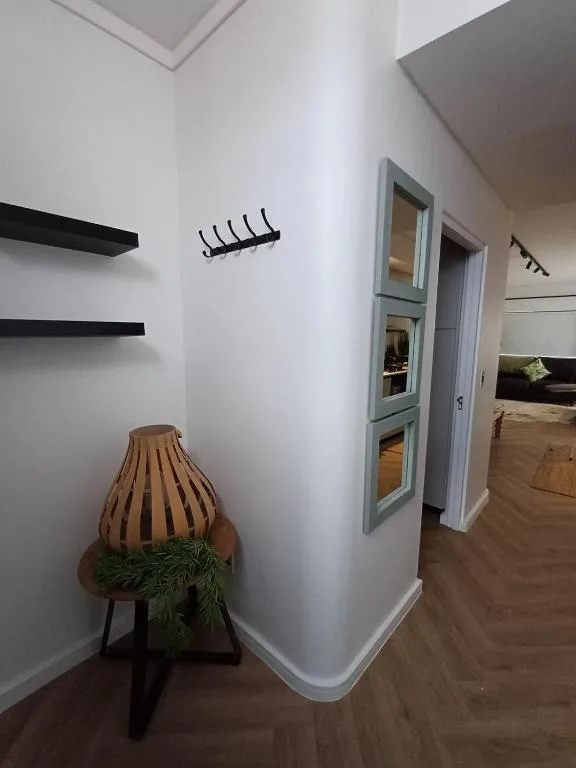 Modern hallway with floating shelves, woven basket, and mirrored door