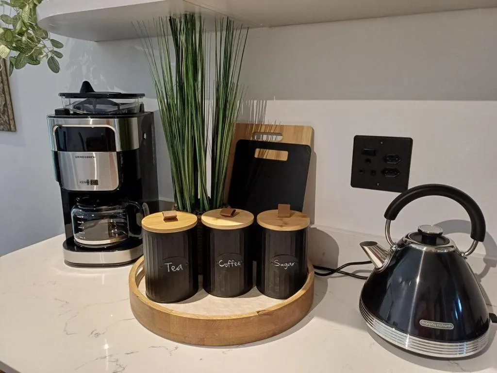 Kitchen counter with coffee maker, kettle, and labeled tea storage containers