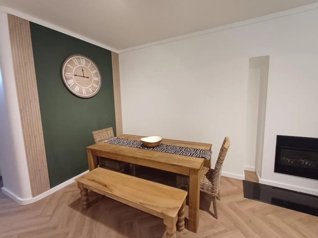 Wooden dining table with bench seating and woven chairs in bright room