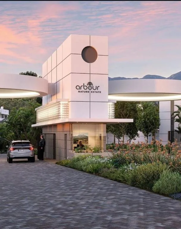 Modern white villa with Arbour Nature Estate signage and mountain views at dusk