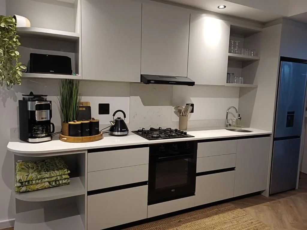 Modern kitchen with white cabinetry, gas cooktop, and stainless steel appliances