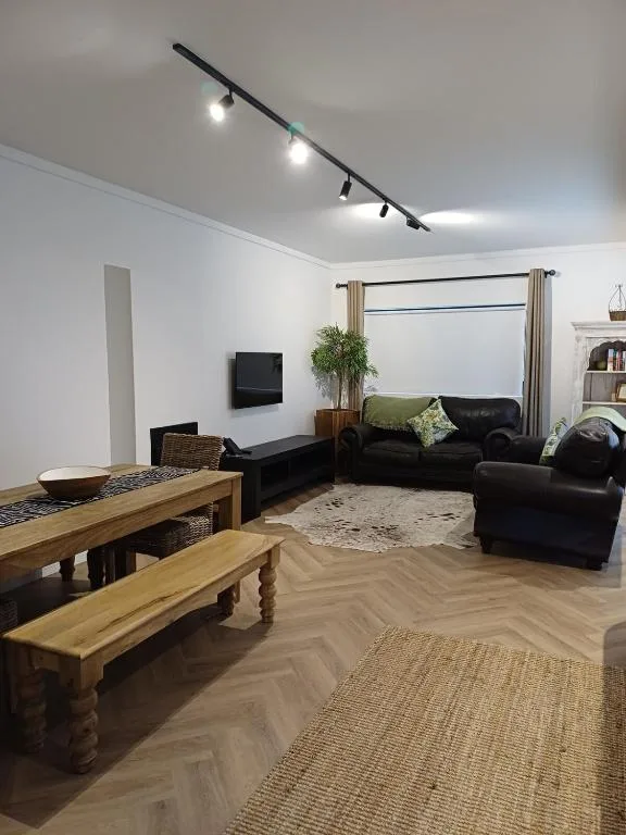 Modern living room with black leather sofas and wooden dining table