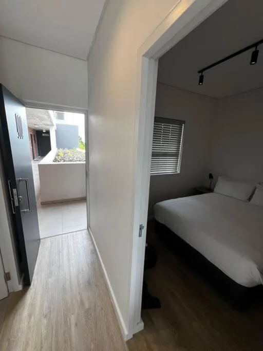 Modern bedroom with double bed and access to open-plan living area