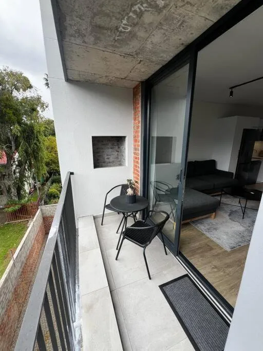 Modern patio with black chairs and small table overlooking garden