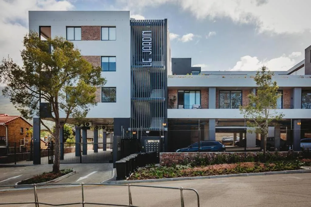 Modern multi-story apartment building with white and brick facade, contemporary architecture
