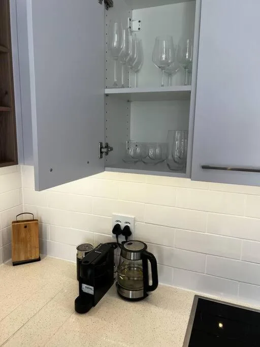 Kitchen counter with coffee maker and open glass cabinet storage