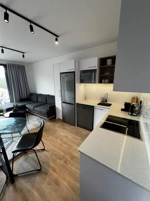 Modern kitchen with white cabinetry, black appliances, and island counter