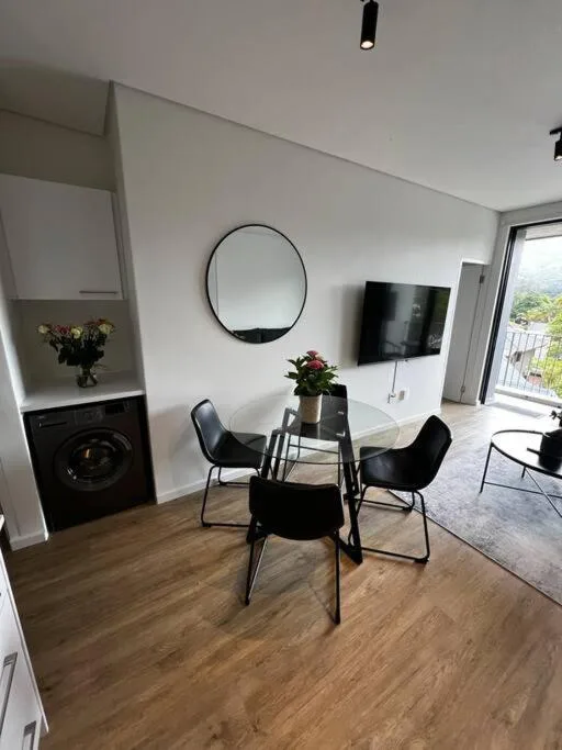 Modern lounge with dining table, TV, fireplace, and mountain views