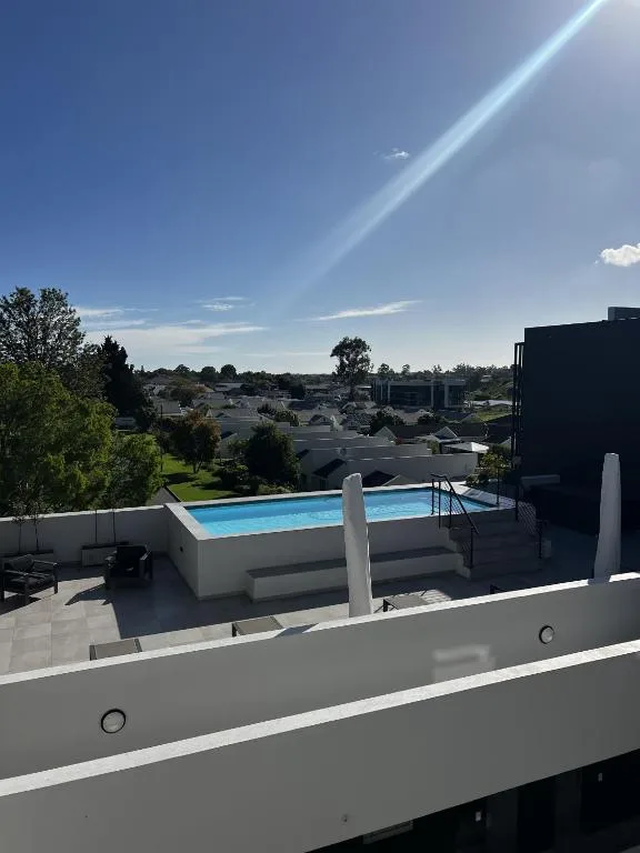 Modern swimming pool on rooftop deck overlooking George town and surrounding landscape