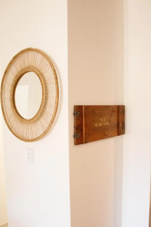 Woven circular mirror and vintage wooden box wall decor