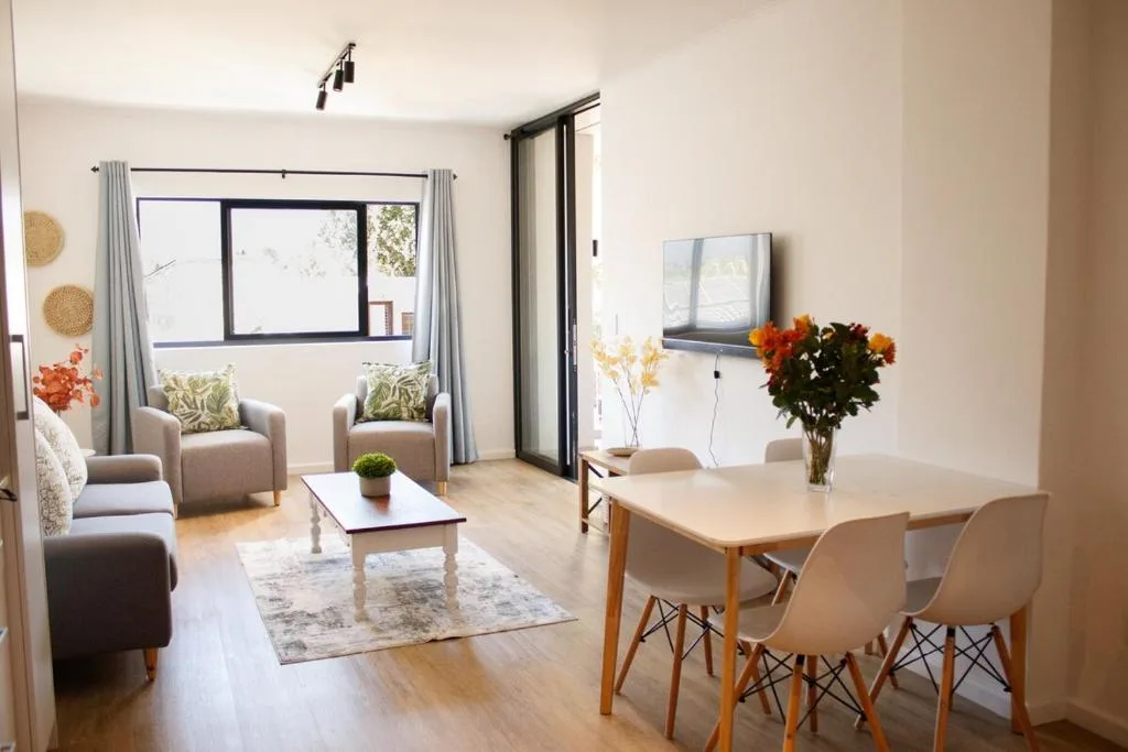 Bright open-plan lounge and dining area with comfortable seating and wooden table