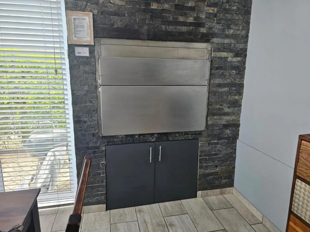 Modern wall-mounted whiteboard with black storage cabinet below