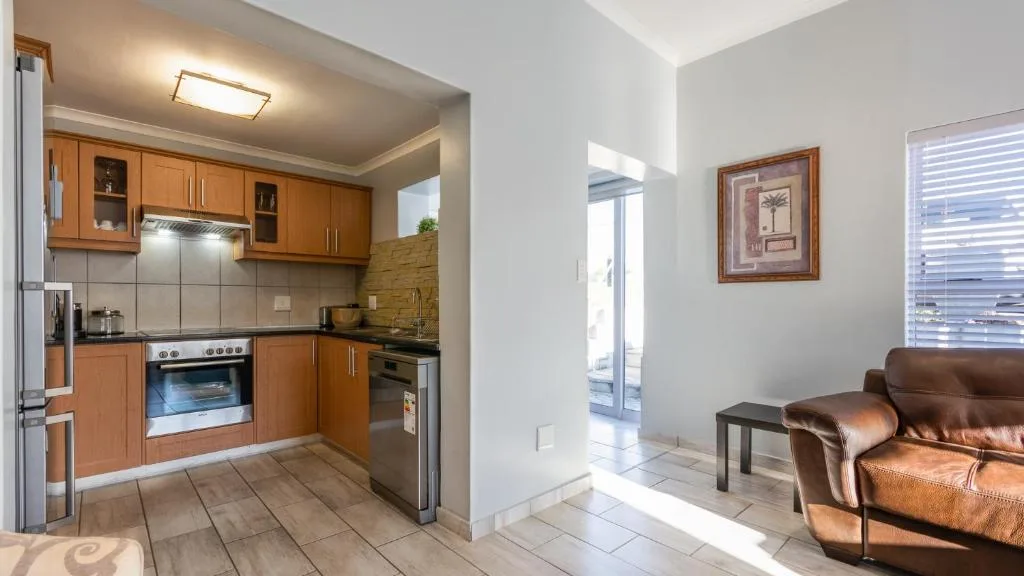 Modern kitchen with wooden cabinetry, stainless steel appliances, and tiled flooring
