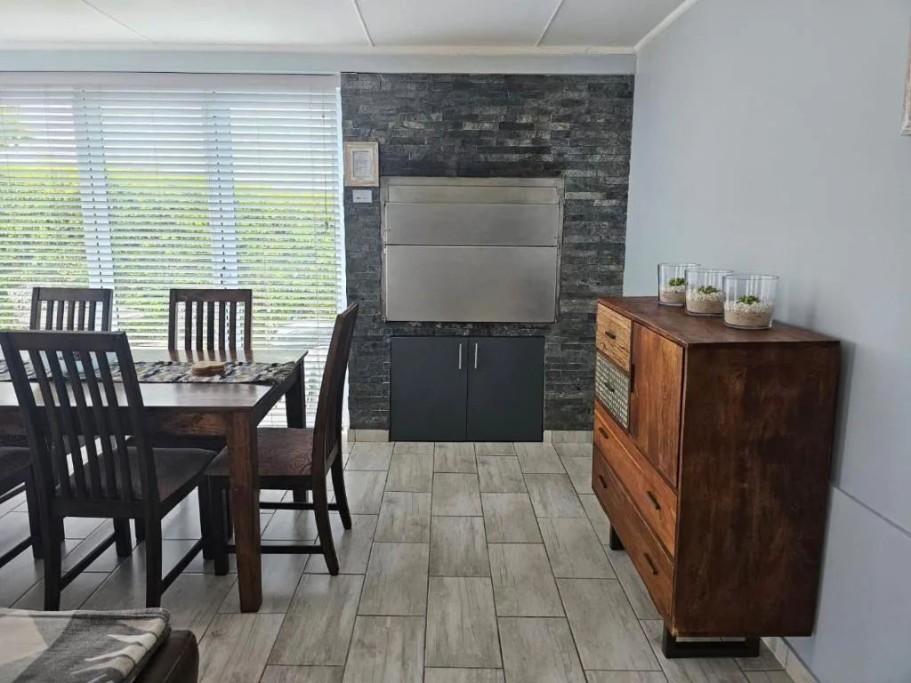 Modern kitchen with dining table, dark brick backsplash, stainless steel appliances