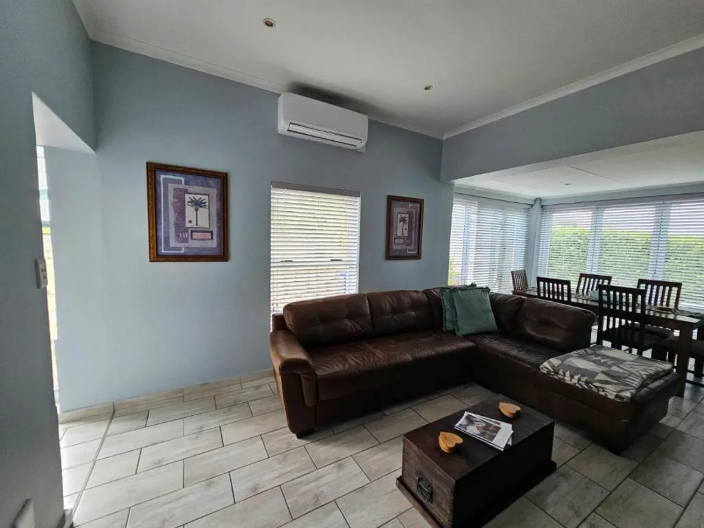 Spacious living room with brown leather sectional sofa and coffee table