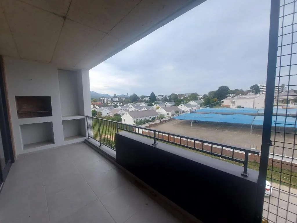 Covered balcony overlooking suburban town with mountains and pool area