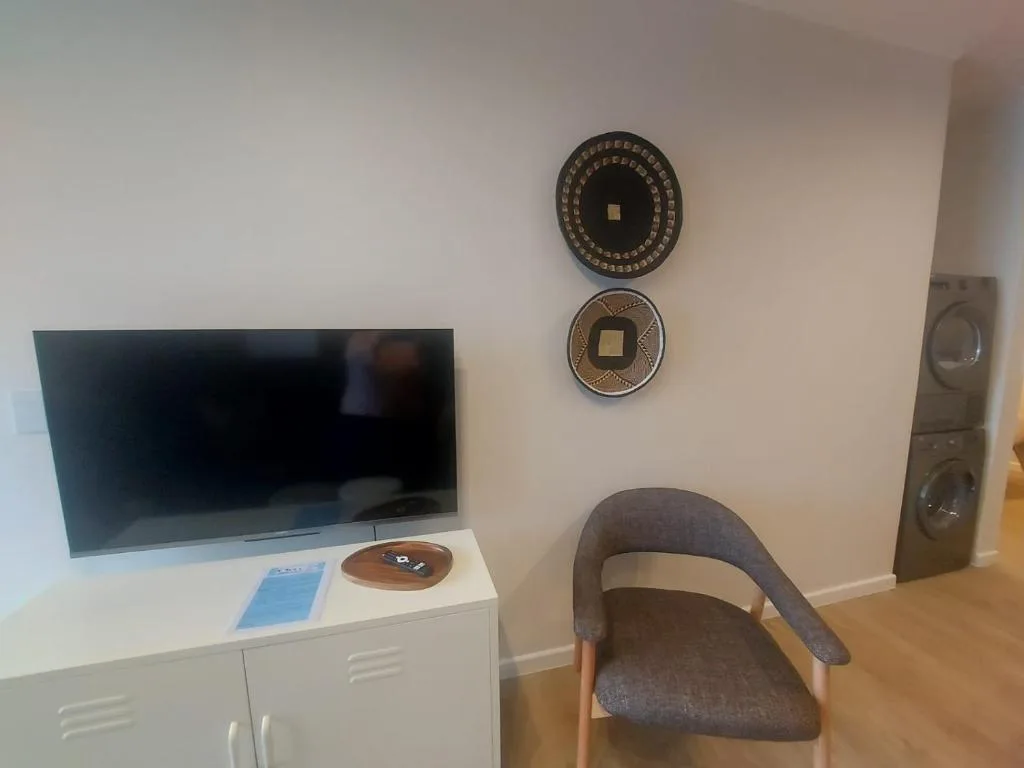 Modern lounge with flat-screen TV, decorative wall plates, and comfortable seating