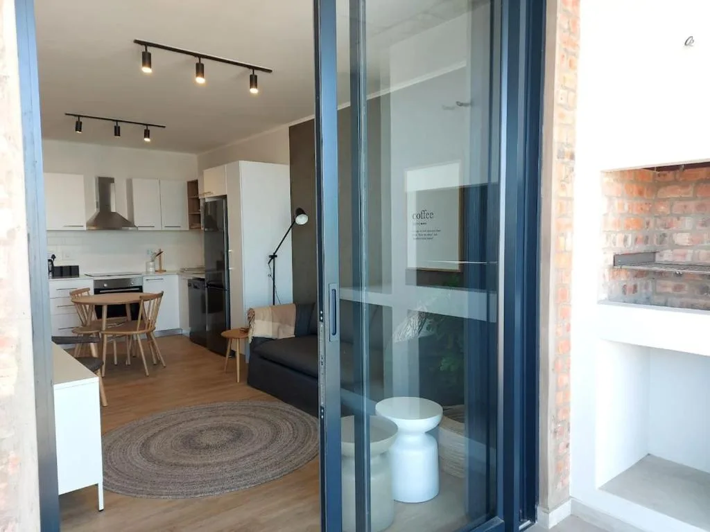 Modern open-plan lounge with kitchen, dining area, and contemporary furnishings