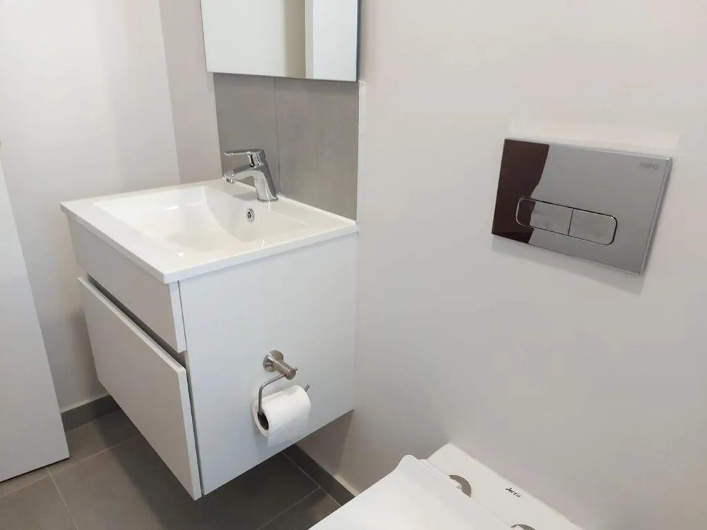 Modern bathroom with white vanity sink and grey tile accents
