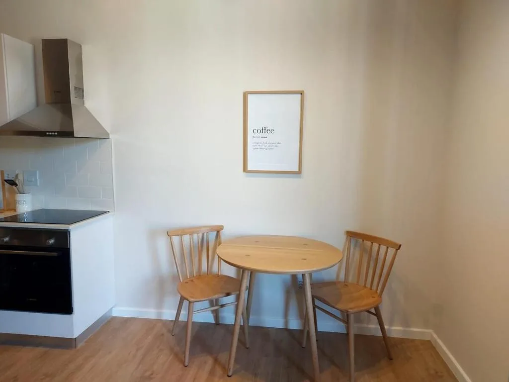 Bright dining area with round wooden table and two chairs