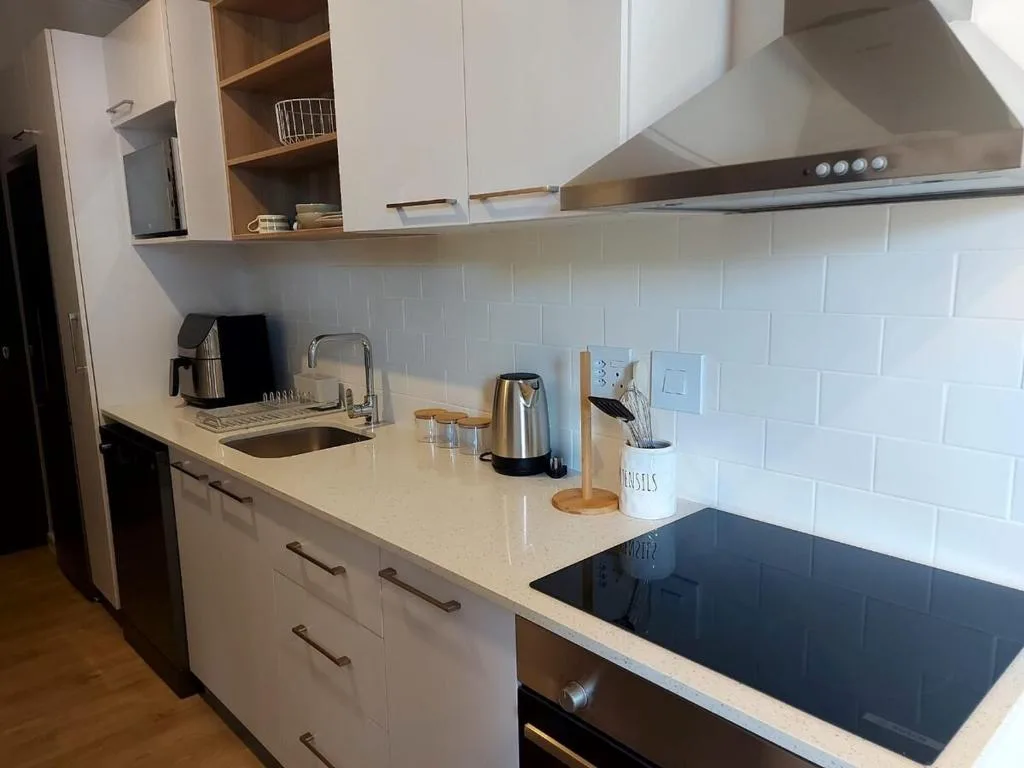 Modern kitchen with white cabinetry, induction cooktop, and subway tile backsplash