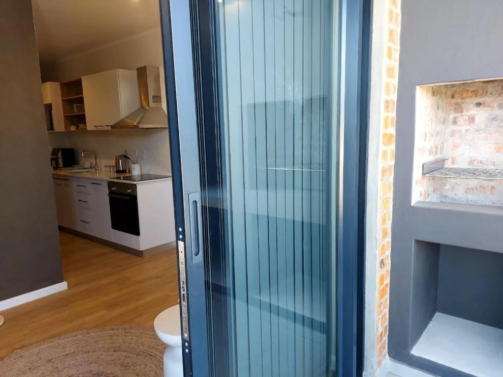 Modern kitchen with white cabinetry, black oven, and wooden flooring