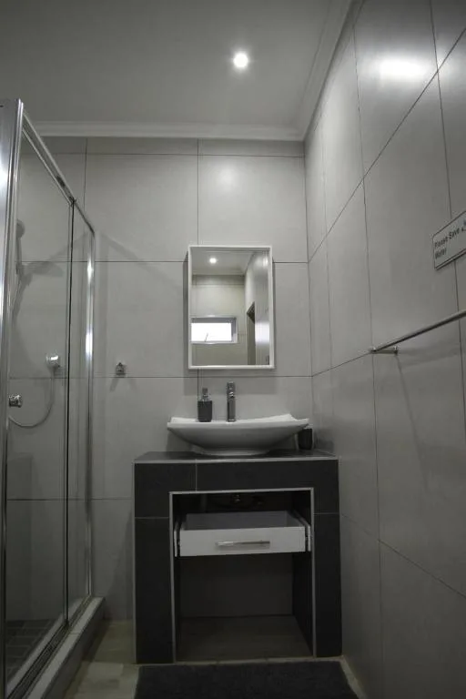 Modern bathroom with vanity, mirror, and enclosed glass shower