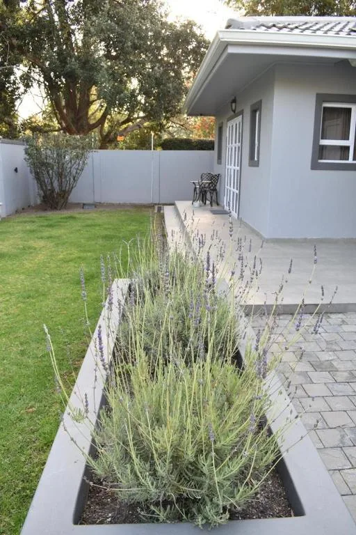 Modern white cottage with manicured garden and lavender planting beds