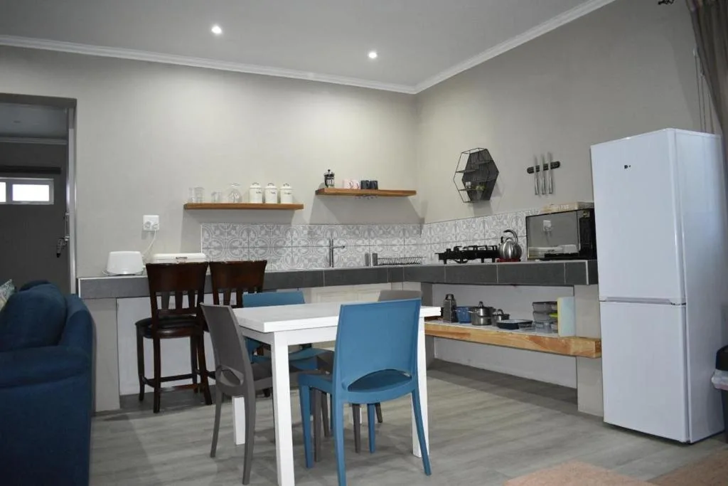 Modern open-plan kitchen with white cabinetry, gas cooktop, and dining area