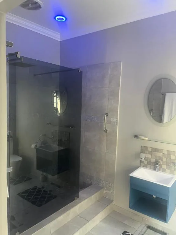 Modern bathroom with large walk-in shower enclosure and vanity sink