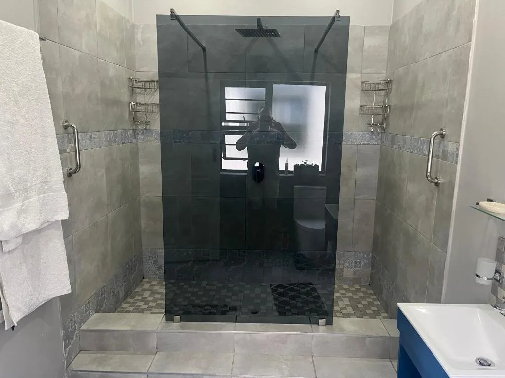 Modern bathroom with walk-in shower enclosure and neutral tiling